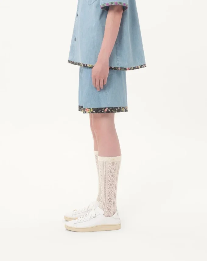 Bermudas vaqueras con estampado floral en el bajo Bermudas vaqueras con estampado floral en el bajo