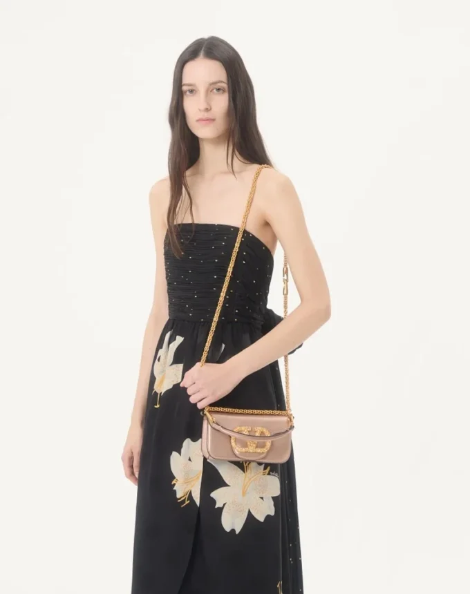 Bolso bandolera pequeño Valentino Garavani Locò en piel de becerro laminada con logotipo joya Bolso bandolera pequeño Valentino Garavani Locò en piel de becerro laminada con logotipo joya