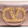 Bolso bandolera pequeño Valentino Garavani Locò en piel de becerro laminada con logotipo joya Bolso bandolera pequeño Valentino Garavani Locò en piel de becerro laminada con logotipo joya