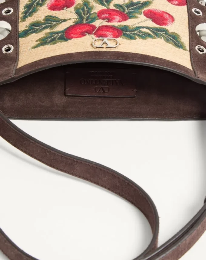 Bolso bandolera pequeño Valentino Garavani Nellcôte en rafia jacquard con estampado Cherryfic Bolso bandolera pequeño Valentino Garavani Nellcôte en rafia jacquard con estampado Cherryfic