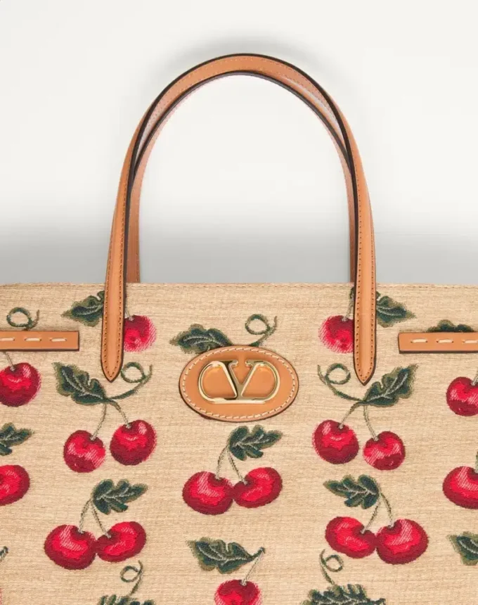 Bolso shopping mediano Antibes de Valentino Garavani en rafia jacquard con motivo Cherryfic Bolso shopping mediano Antibes de Valentino Garavani en rafia jacquard con motivo Cherryfic