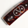 Pinza para el pelo con el logotipo Vlogo en resina, metal y cristales Pinza para el pelo con el logotipo Vlogo en resina, metal y cristales