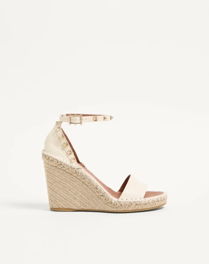 Sandalias de cuña con doble tachuela Rockstud en piel de becerro granulada de 105 mm Sandalias de cuña con doble tachuela Rockstud en piel de becerro granulada de 105 mm